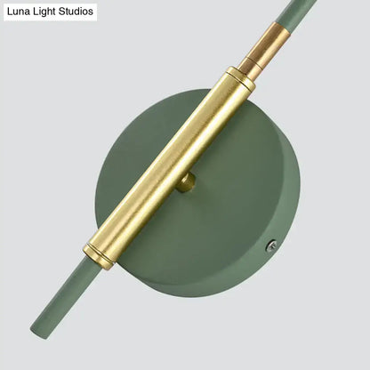 Gold rod wall sconce with green circular backplate and brass hardware on Tampa Home & Garden Store