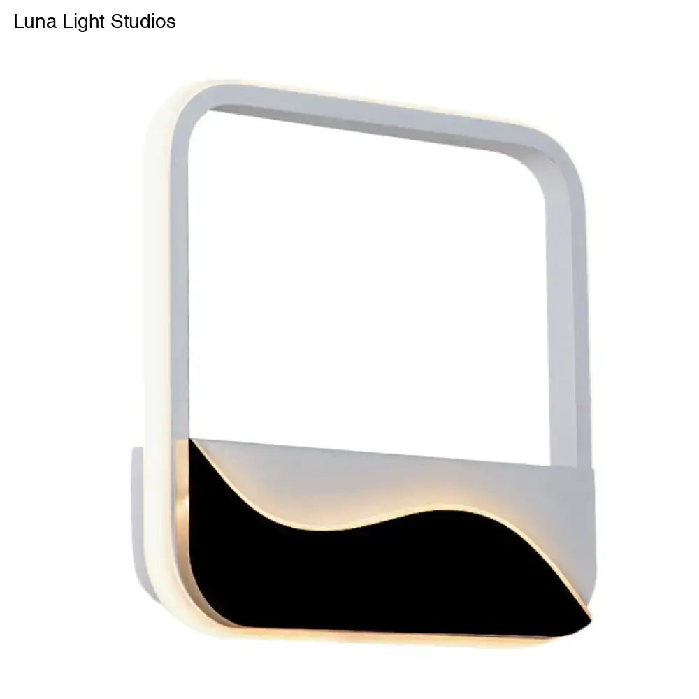 Black and white wall sconce with white frame and black curved base that glows along lower edge on Tampa Home & Garden Store
