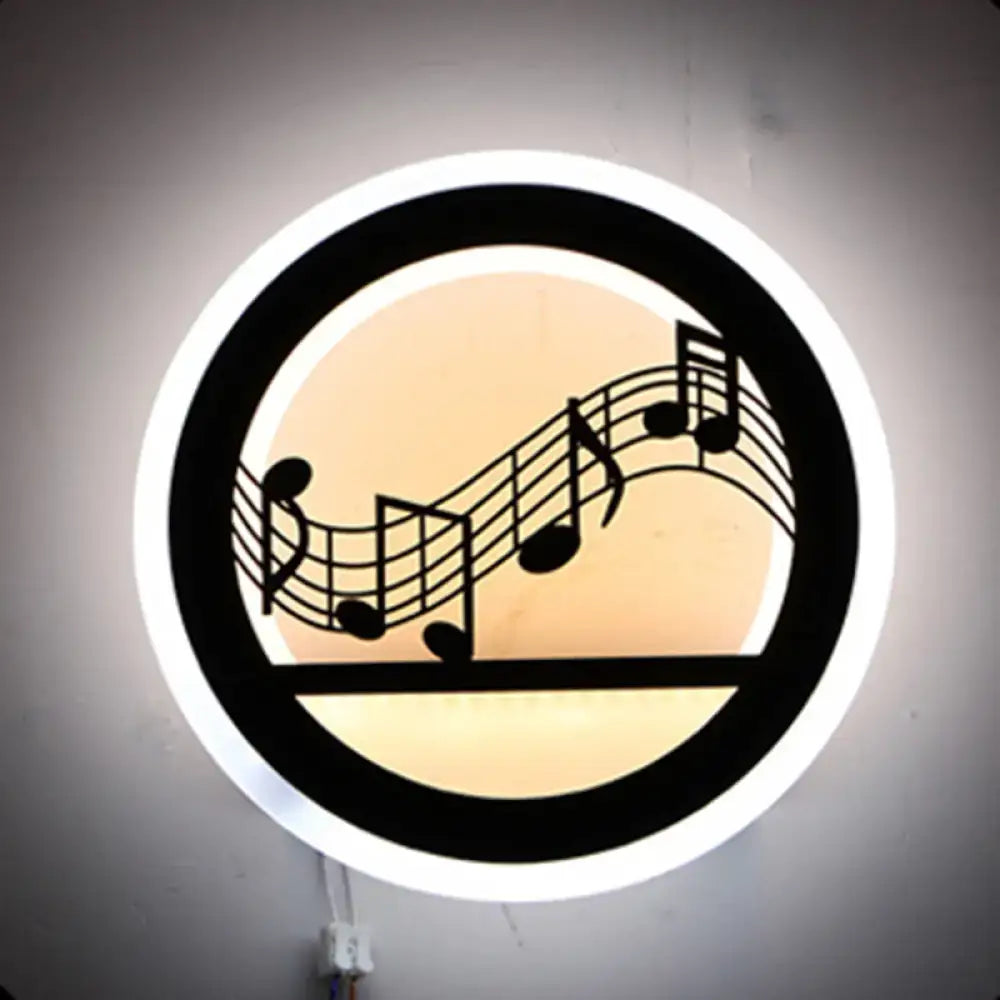 Black circular acrylic wall sconce with music notes and warm glow on Tampa Home & Garden Store