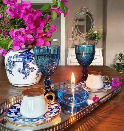 Stevvex blue glass oil candle on a mirrored tray with two goblet candles and white porcelain cups on Tampa Home & Garden Store