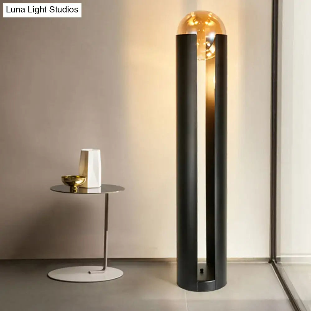 Floor lamp with black pillars and glass globe beside a round table with white vase on Tampa Home & Garden Store