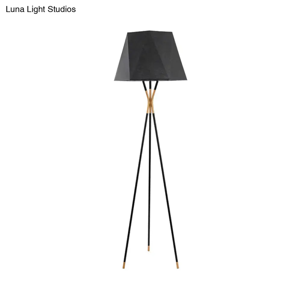 Tripod floor lamp with angular black shade and gold-tone joints on Tampa Home & Garden Store