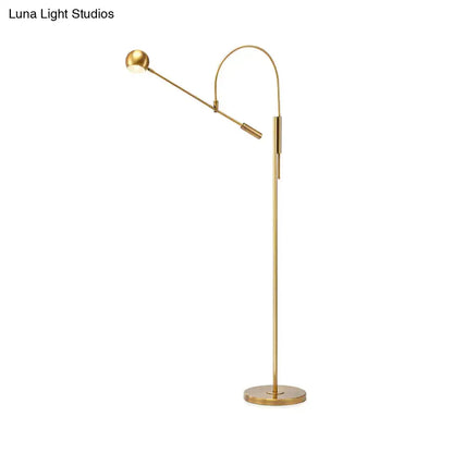 Gold floor lamp with adjustable brass arm and round base on Tampa Home & Garden Store