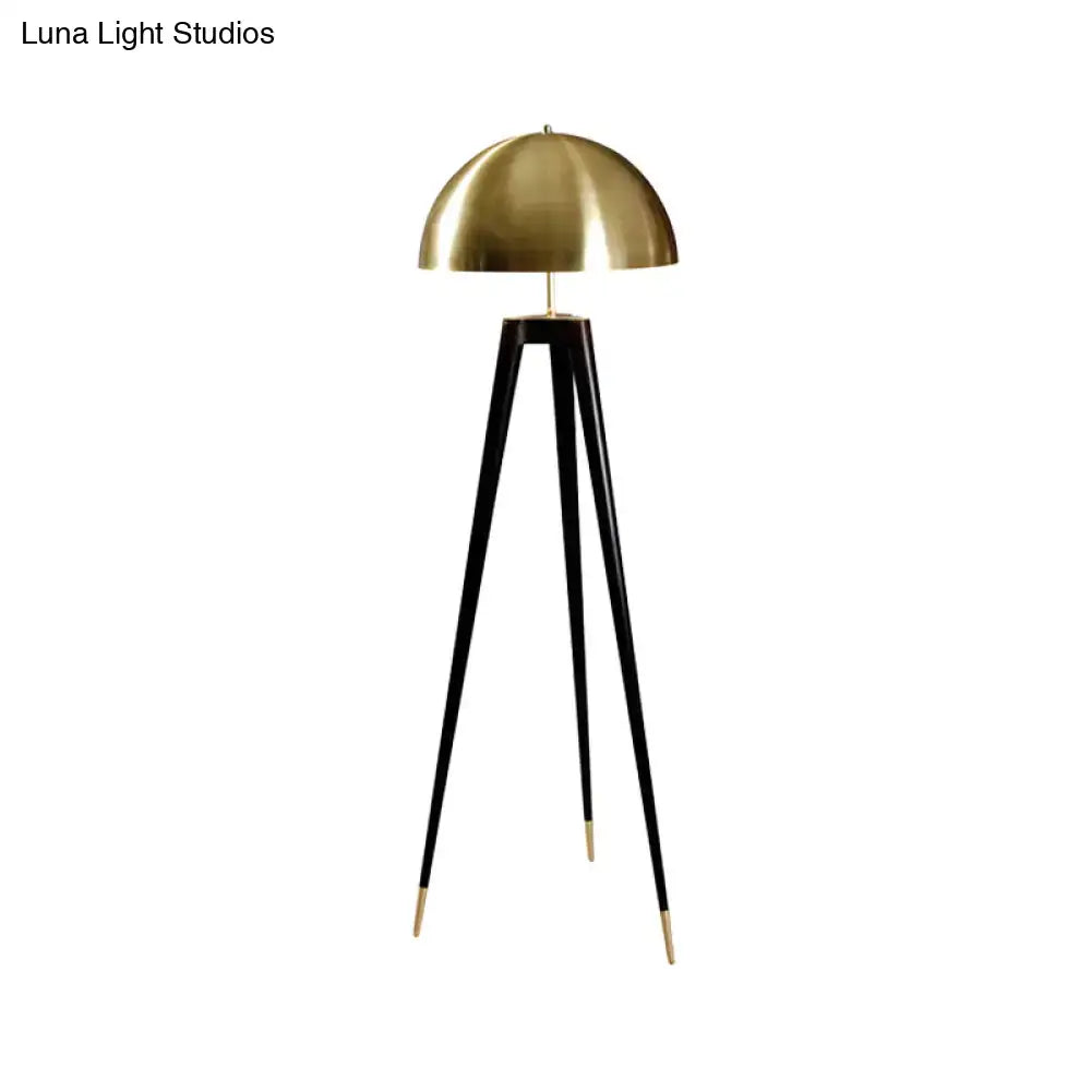 Brass dome floor lamp on a sleek black tripod with gold-tipped feet on Tampa Home & Garden Store