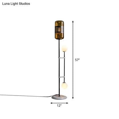 Floor lamp with amber glass shade and two globe bulbs on a slim black metal stand 57in tall on Tampa Home & Garden Store