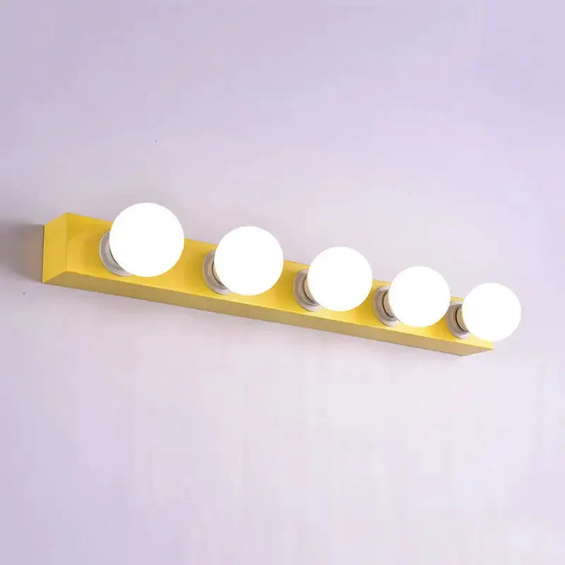 Decorbites six-bulb vanity light fixture on yellow bar with white globe bulbs on Tampa Home & Garden Store