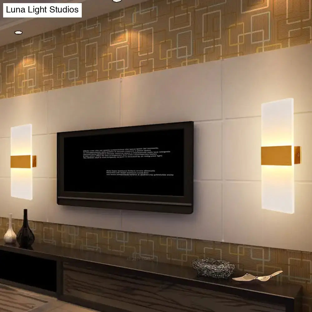 Metal oval LED wall sconce by Decorbites with frosted white panels and gold band, flanking a TV on Tampa Home & Garden Store