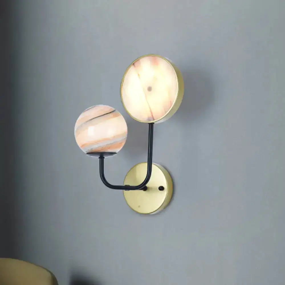 Modern peach and cream glass sconce light with brass wall mount, double-globe design on Tampa Home & Garden Store
