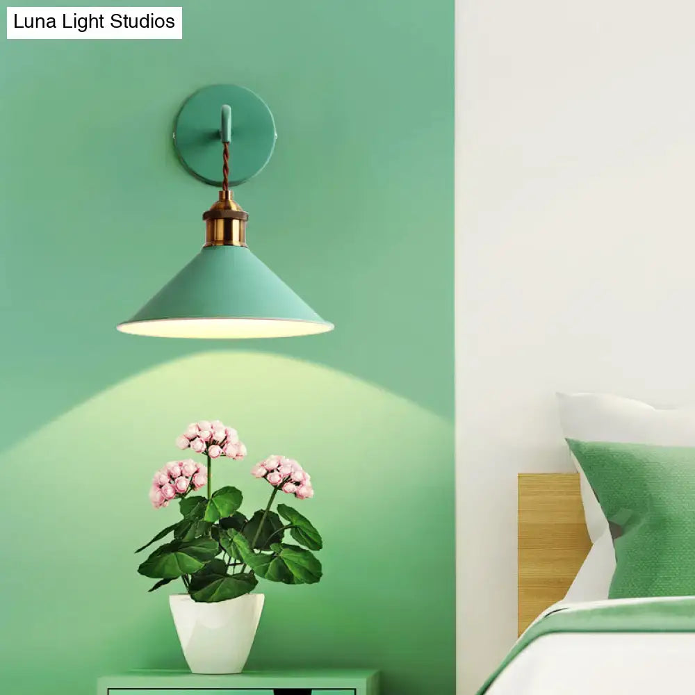 Pink conical metal sconce by Decorbites, brass detail, wall mount with warm light on green wall on Tampa Home & Garden Store