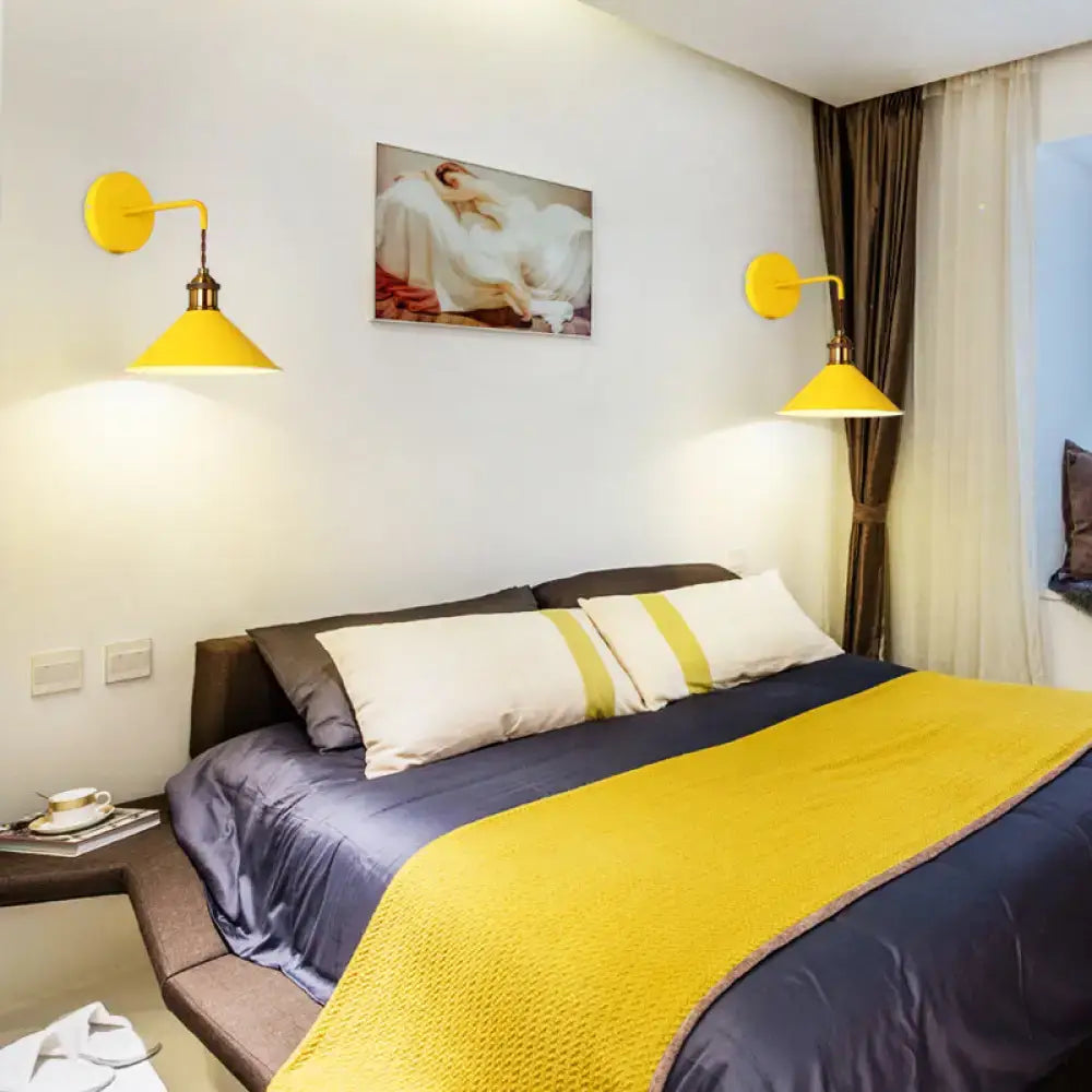 Two yellow conical metal wall sconces above bed provide warm lighting on Tampa Home & Garden Store