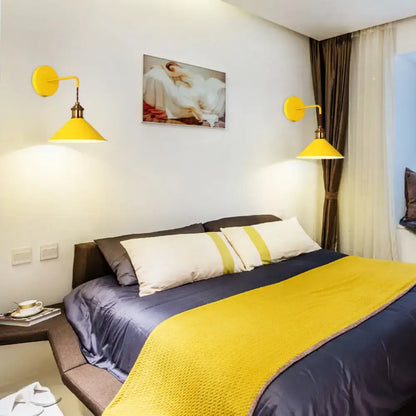Two yellow conical metal wall sconces above bed provide warm lighting on Tampa Home & Garden Store
