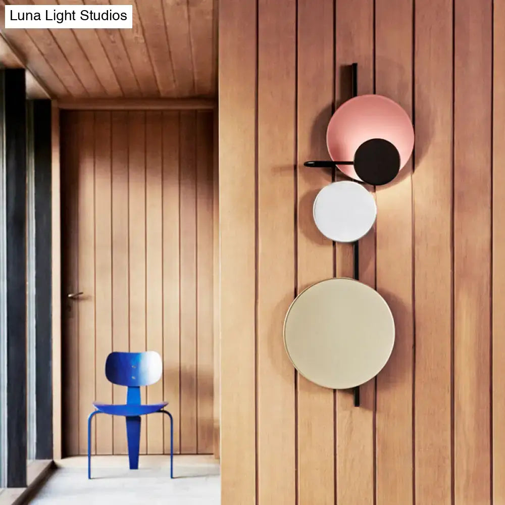 Pink gold circular wall light with overlapping discs on a black mount on Tampa Home & Garden Store