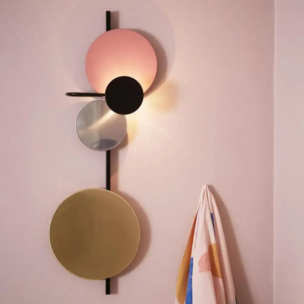 Pink gold circular wall light by Decorbites with layered metal discs on a slim black rod on Tampa Home & Garden Store