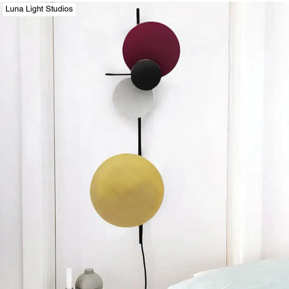 Pink circular wall light with four colored discs on a slim black rod by Decorbites on Tampa Home & Garden Store
