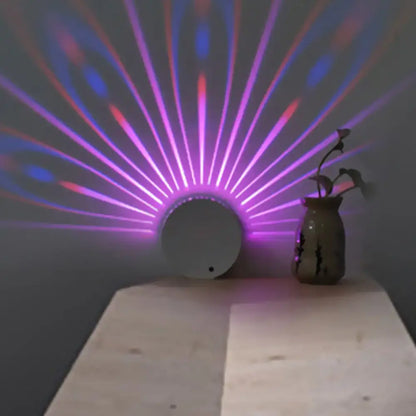 Peacock LED Wall Lamp white round base casts purple fan rays on wall beside a vase on Tampa Home & Garden Store