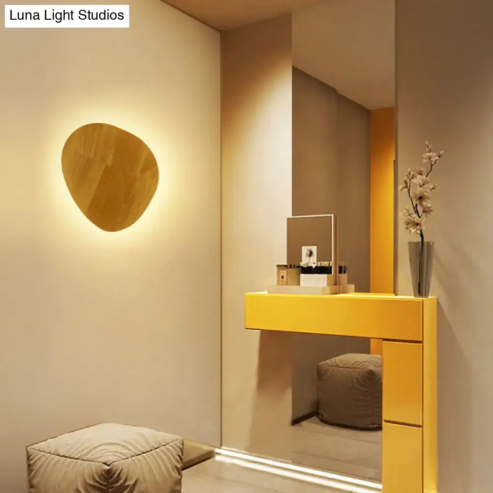 Decorbites Wood LED wall light with round wood veneer panel emits warm ambient glow on beige wall on Tampa Home & Garden Store
