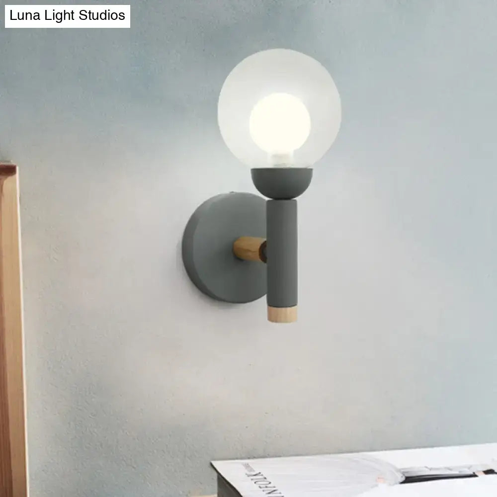 Sage Macaron Wall Sconce by Decorbites with gray metal arm, wood end cap, and glass globe on Tampa Home & Garden Store