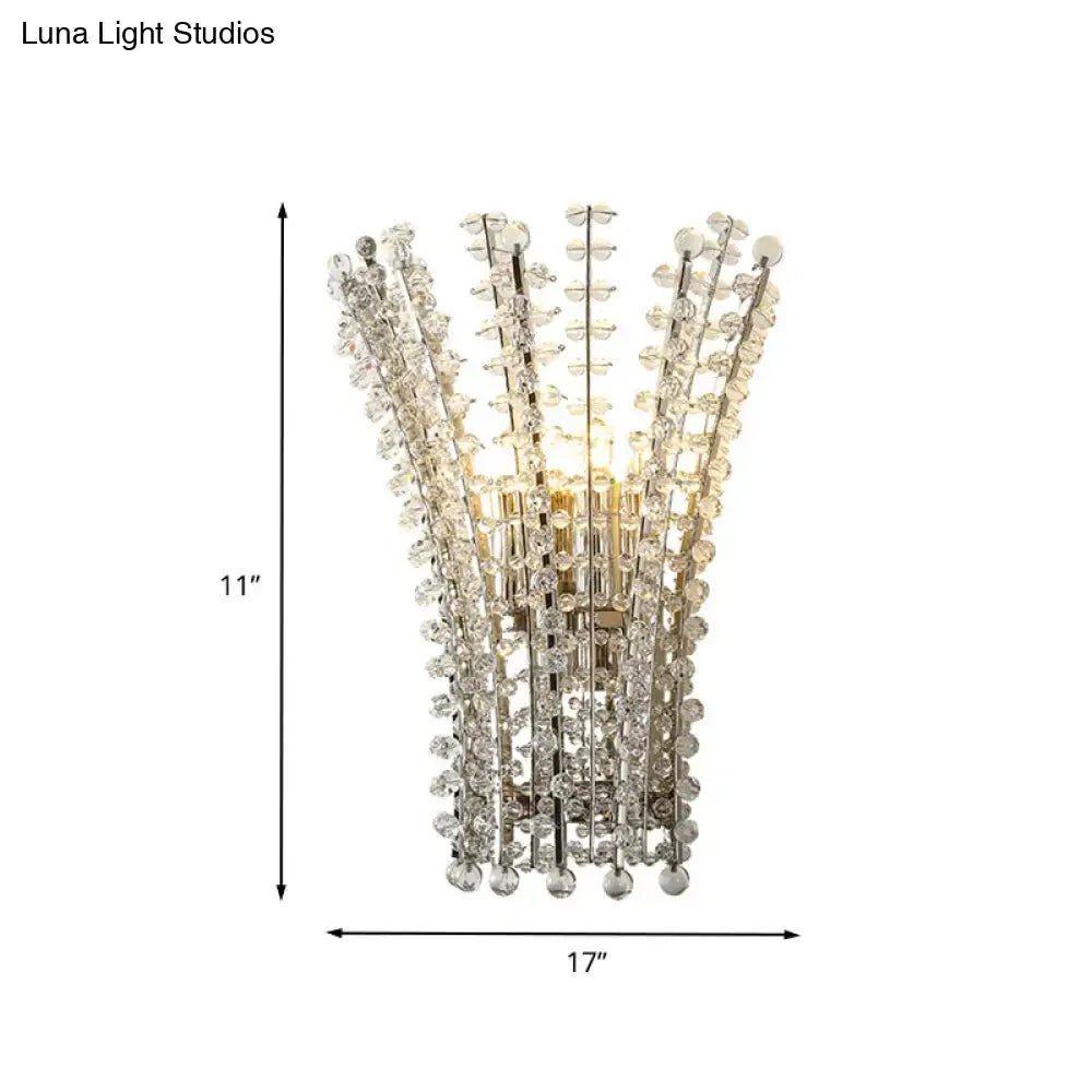 Silver crystal wall sconce with cascading vertical strands forming a fan, warm glow on Tampa Home & Garden Store