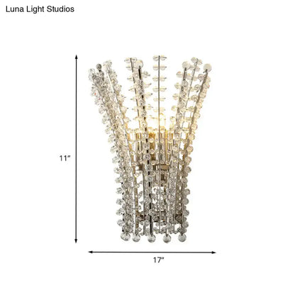 Silver crystal wall sconce with cascading vertical strands forming a fan, warm glow on Tampa Home & Garden Store