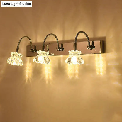 Silver crystal vanity light with four gooseneck arms and glass flower shades on a backplate on Tampa Home & Garden Store