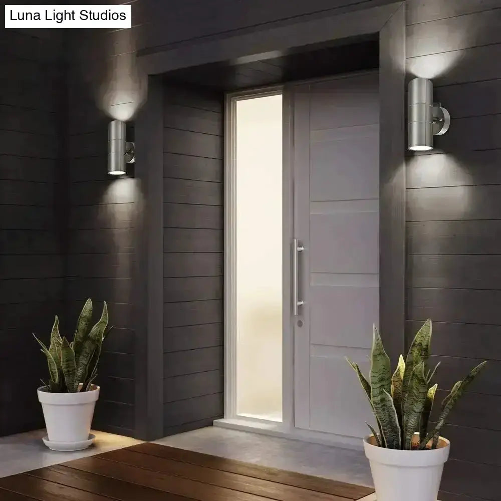 Modern silver cylindrical outdoor wall sconces by Decorbites, paired beside entry door on Tampa Home & Garden Store
