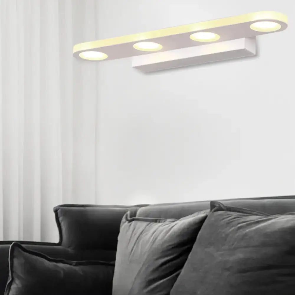 Silver oblong LED wall light by Decorbites with three round LEDs, wall mounted above a sofa on Tampa Home & Garden Store
