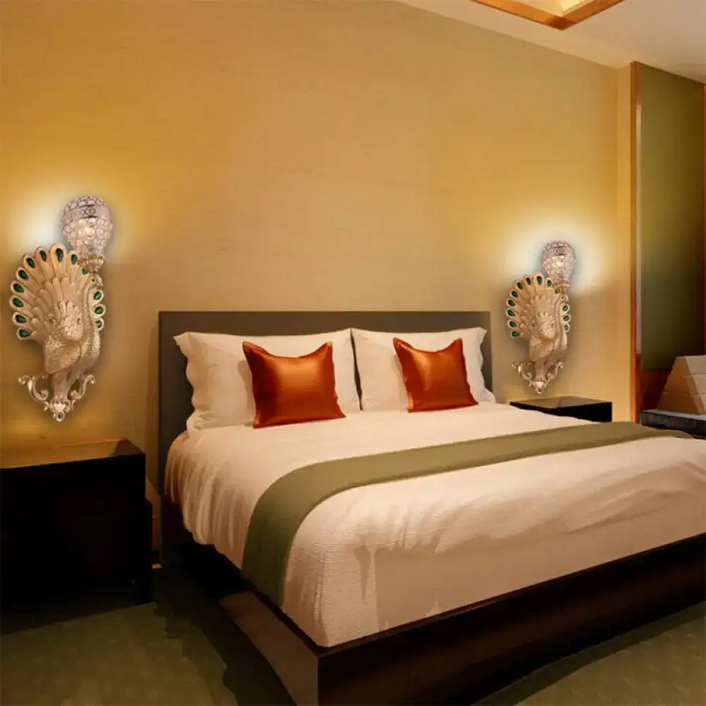 Silver Peacock Wall Sconce pair with green gemstone accents, Decorbites, flanking a bed on Tampa Home & Garden Store