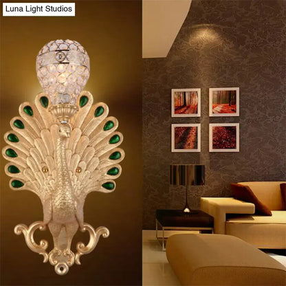 Silver peacock wall sconce with green gemstone accents and crystal shade by Decorbites on Tampa Home & Garden Store