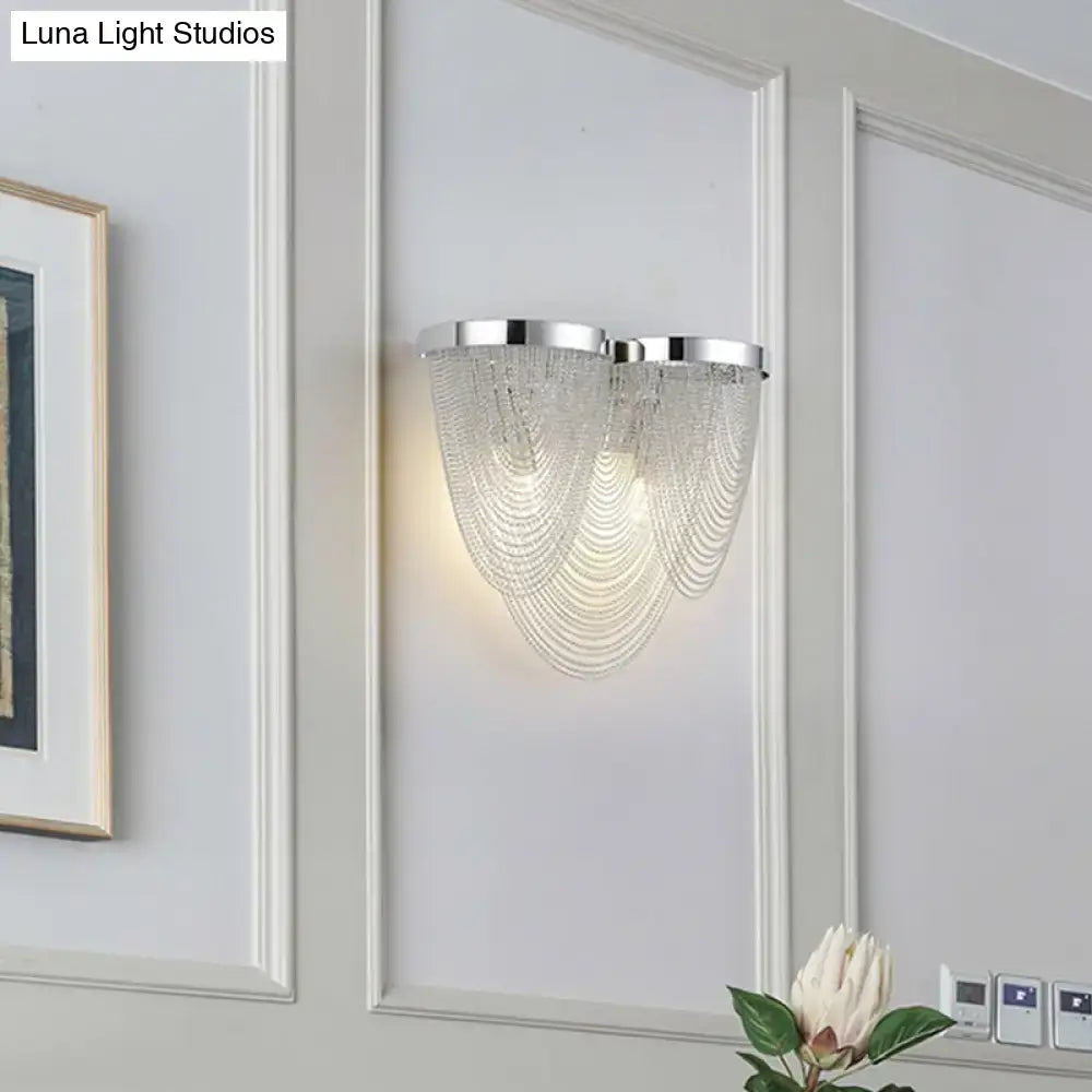 Silver tassel wall sconce by Decorbites with crystal bead strands on a gray paneled wall on Tampa Home & Garden Store