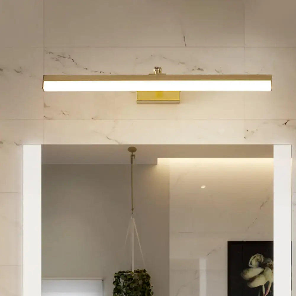 Brass LED wall light bar mounted on a marble tiled bathroom wall above a mirror, warm glow on Tampa Home & Garden Store