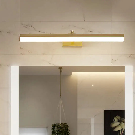 Brass LED wall light bar mounted on a marble tiled bathroom wall above a mirror, warm glow on Tampa Home & Garden Store