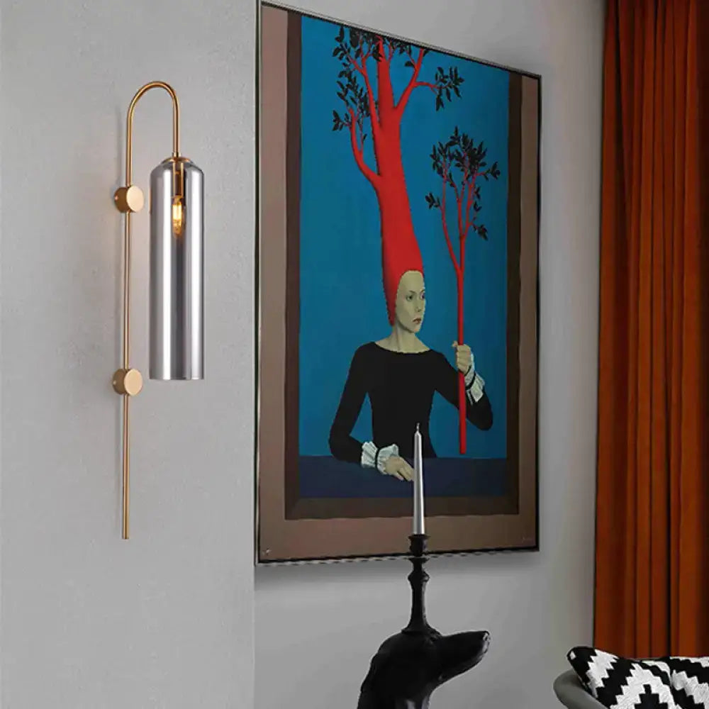 Gray glass cylindrical wall sconce by Decorbites with gold metal arm on Tampa Home & Garden Store