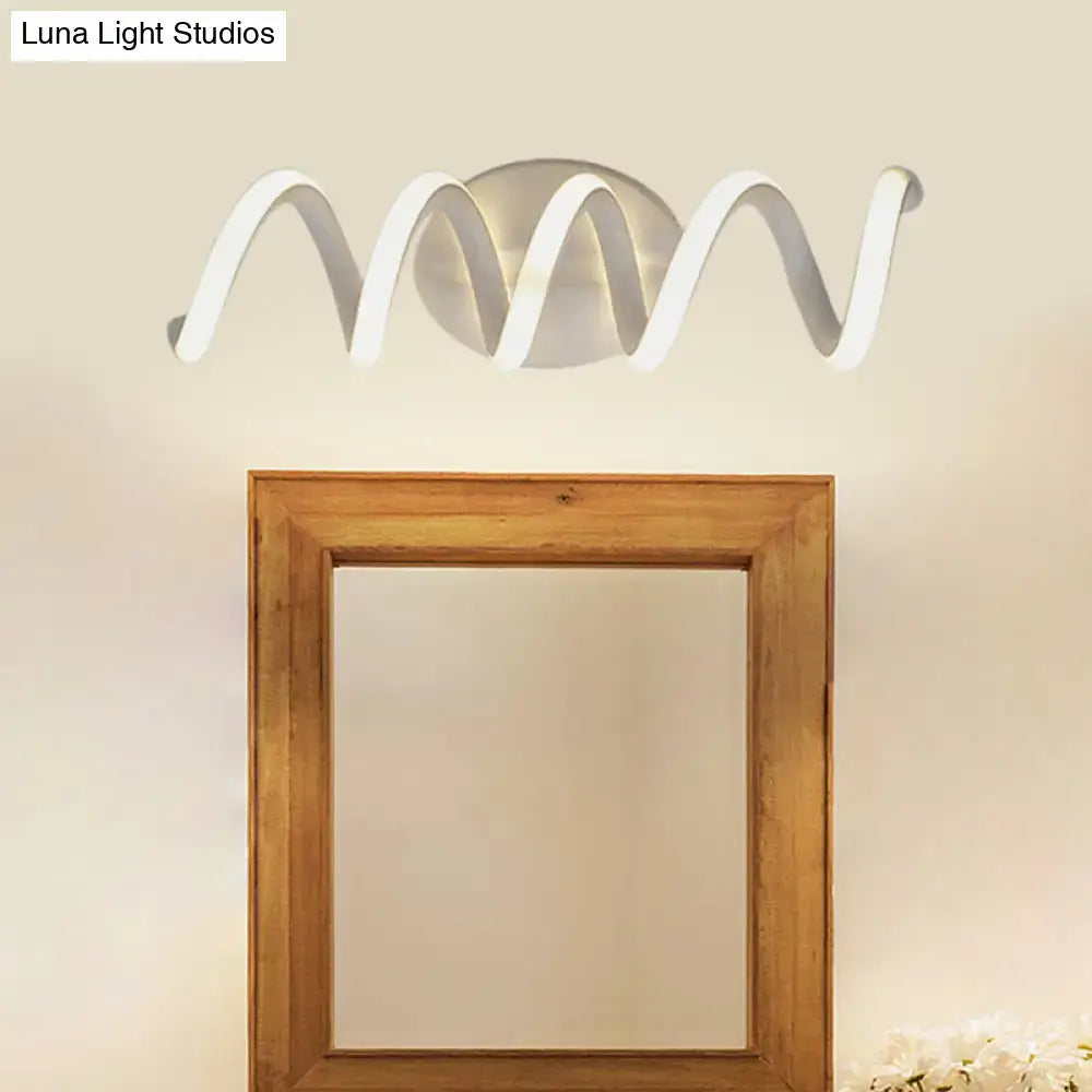 Modern spiral white LED wall sconce with warm glow above a wooden square mirror on Tampa Home & Garden Store