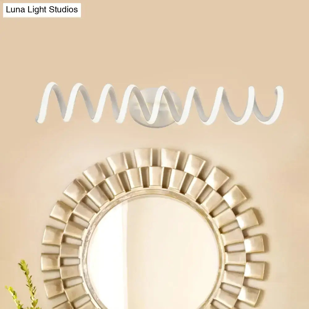 Modern spiral white wall light sconce with warm LED on beige wall above a sunburst mirror on Tampa Home & Garden Store
