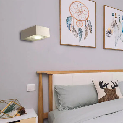 Black Silver LED Wall Sconce by Decorbites above a wooden headboard in a gray bedroom on Tampa Home & Garden Store