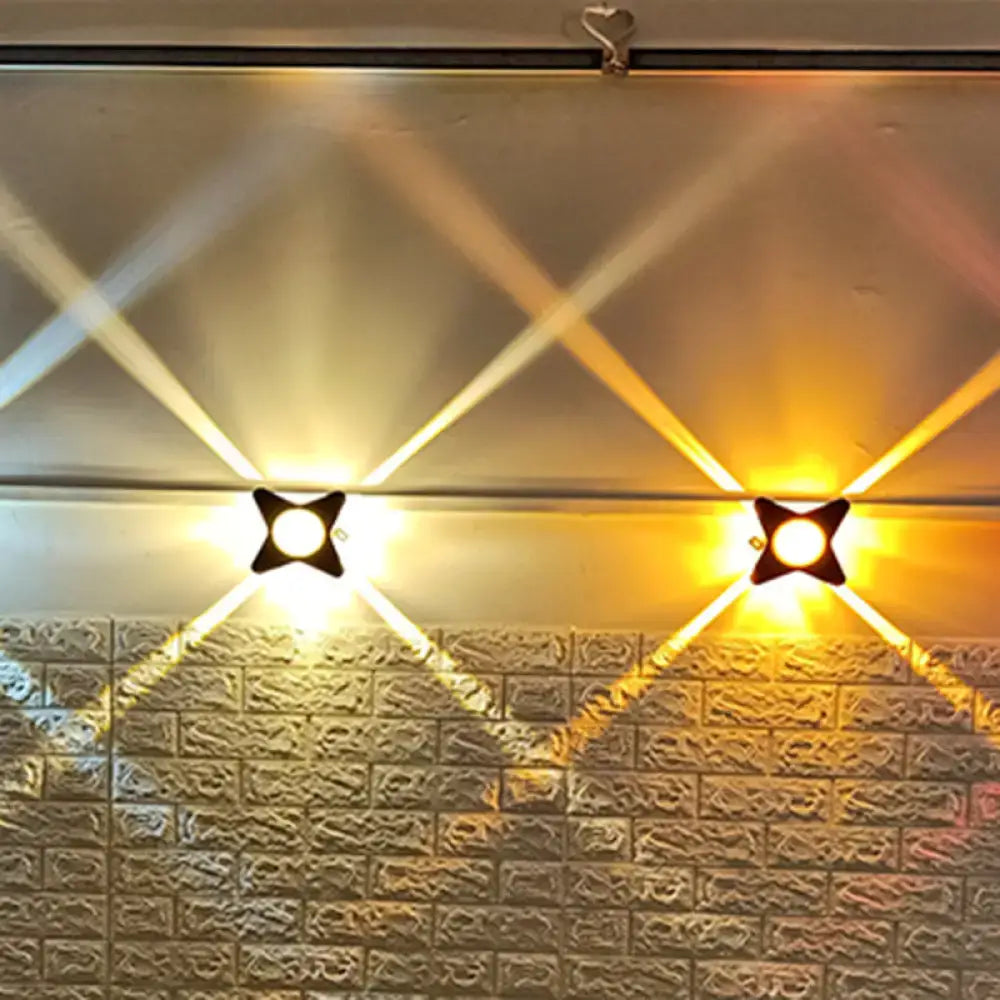 Black Petals Wall Sconce pair with cross-shaped petals, warm white light on brick wall on Tampa Home & Garden Store