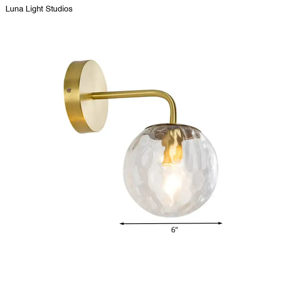 Gold hammered glass living room sconce with brass curved arm and 6-inch globe on Tampa Home & Garden Store
