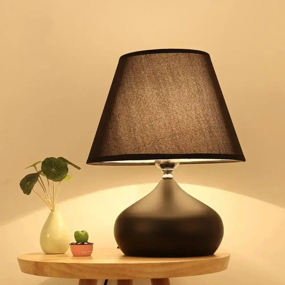 Modern tapered black ceramic table lamp with black shade on a wood table on Tampa Home & Garden Store