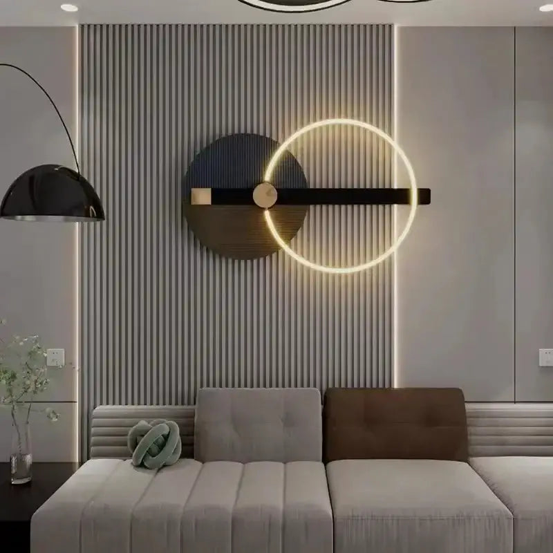 Modern LED wall sconce with a circular gold ring on a black bar against a textured gray wall on Tampa Home & Garden Store
