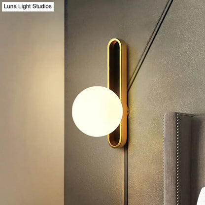Gold wall sconce with vertical oval backplate and frosted white glass globe on Tampa Home & Garden Store