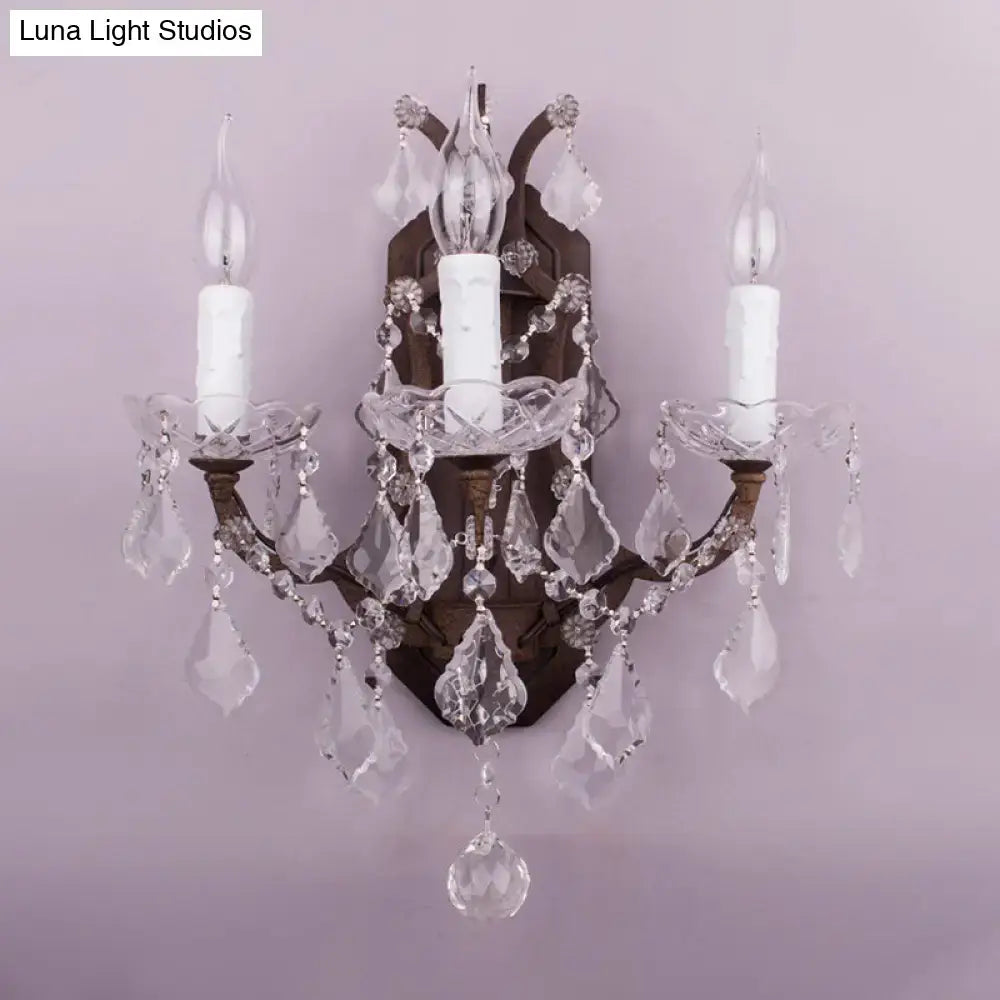 White rust crystal sconce with two candle lights and hanging prisms on wood back on Tampa Home & Garden Store