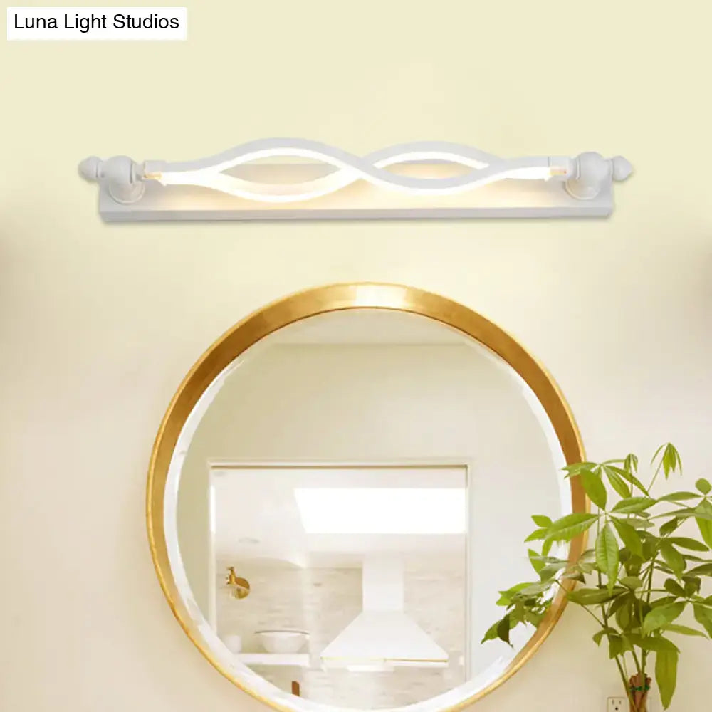 Modern wavy white twist acrylic vanity sconce by Decorbites above a round gold-framed mirror on Tampa Home & Garden Store