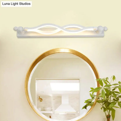 Modern wavy white twist acrylic vanity sconce by Decorbites above a round gold-framed mirror on Tampa Home & Garden Store