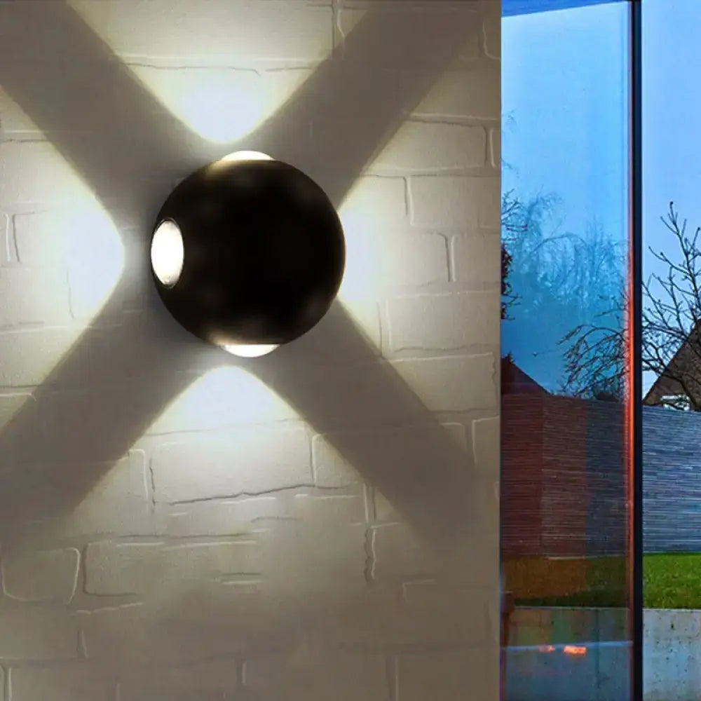 White Dome Wall Sconce dark metal sphere casts cross-shaped light on brick wall on Tampa Home & Garden Store