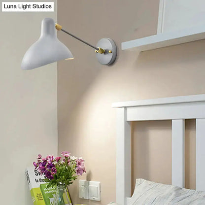 Modern white and gold wall-mounted lamp with adjustable arm above white bed headboard on Tampa Home & Garden Store