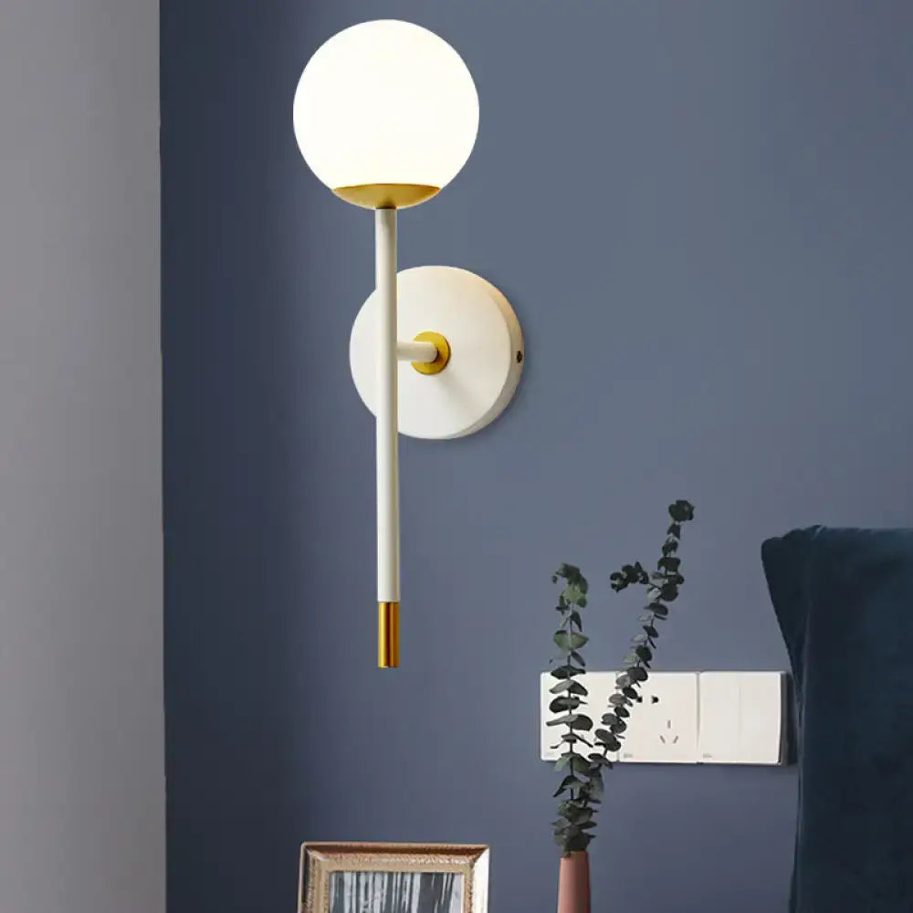 Brass frosted long-arm wall sconce with white globe shade by Decorbites on Tampa Home & Garden Store
