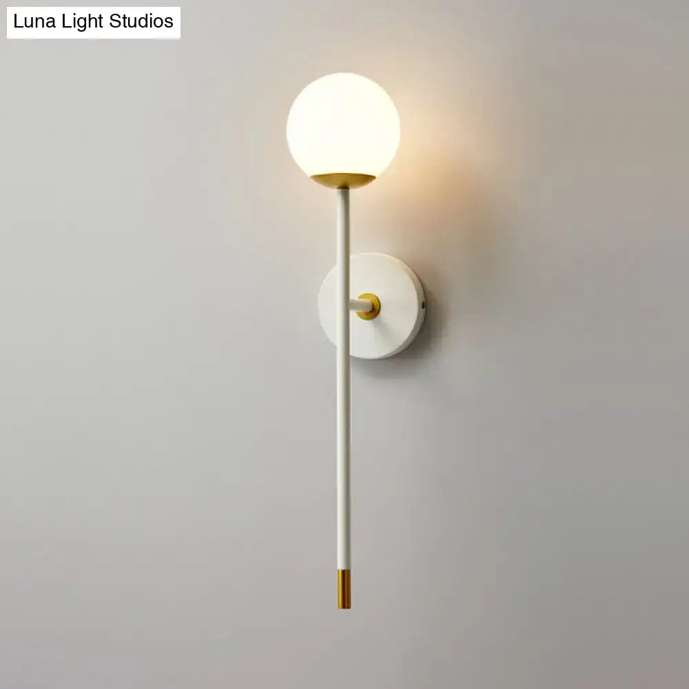 Brass frosted long-arm wall sconce with white stem and round globe by Decorbites on Tampa Home & Garden Store
