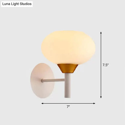 Brass opal-glass minimalist wall sconce with white backplate and stem, 7in wide, warm glow on Tampa Home & Garden Store