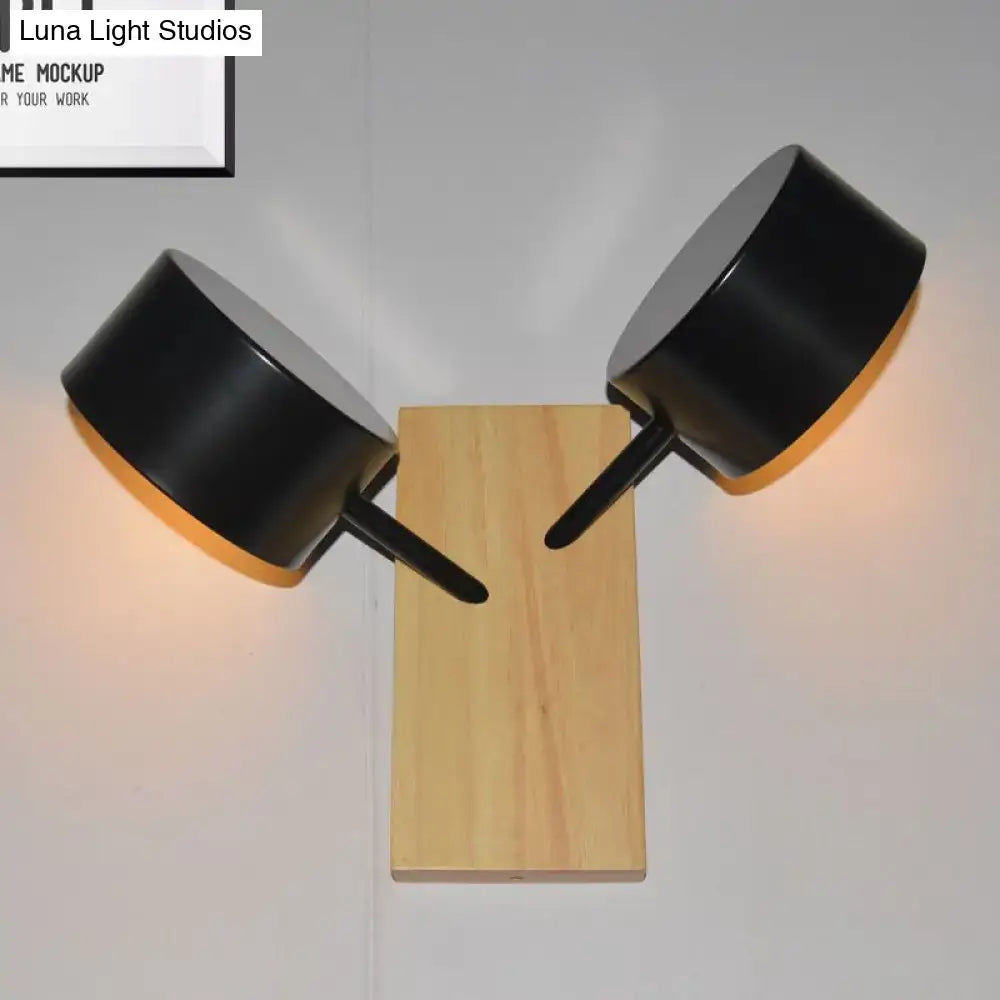 White ceramic drum sconce pair with black metal arms mounted on a wooden backplate on Tampa Home & Garden Store