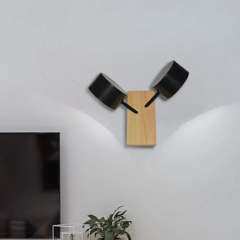 White Ceramic Drum Sconce with dual black cylindrical shades on a natural wood backplate on Tampa Home & Garden Store